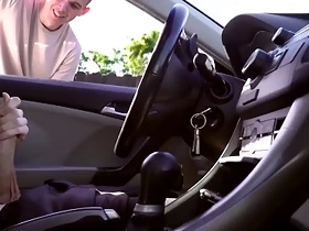 Guy watches other guy stroke his cock in the car while in public